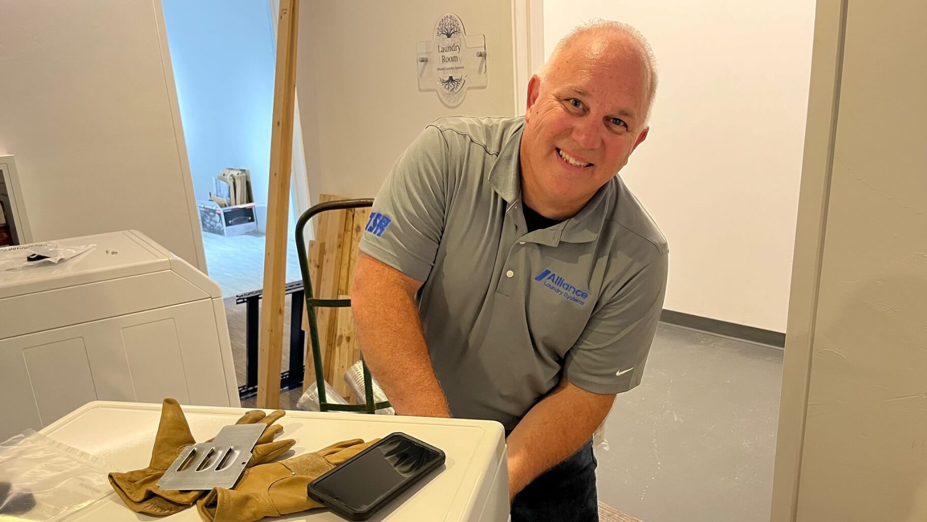Alliance employee setting up donated laundry equipment at Christine Ann center
