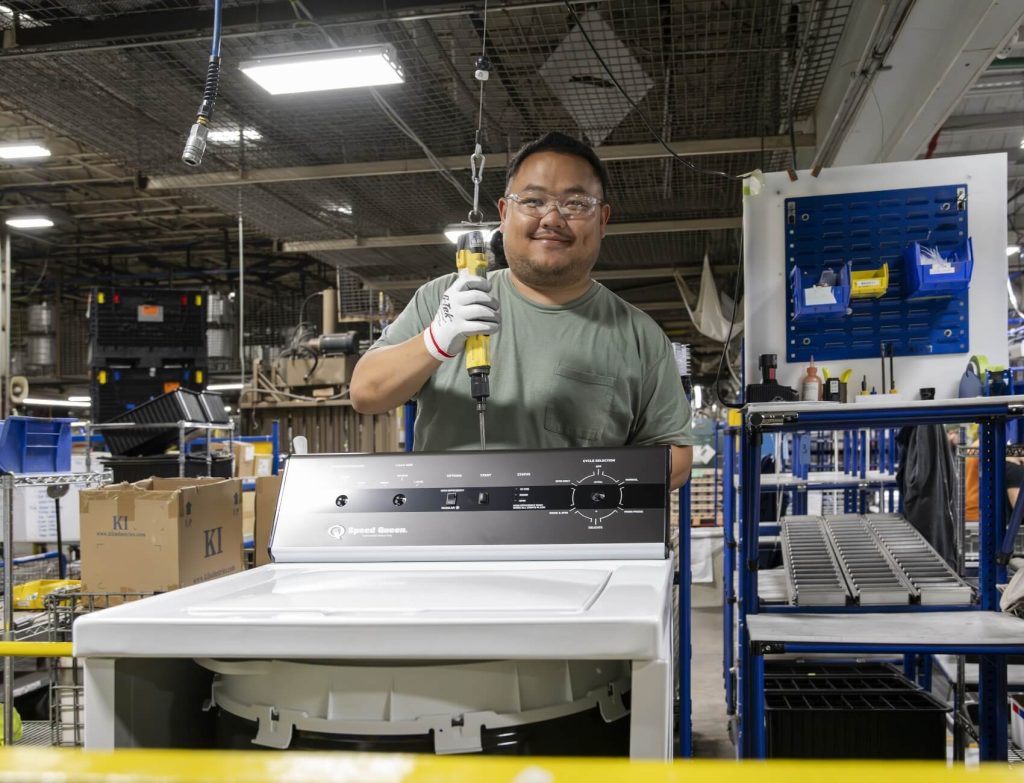 Alliance technician working on Speed Queen washer while wearing safety gear