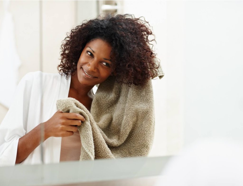 Woman drying hair with clean towel
