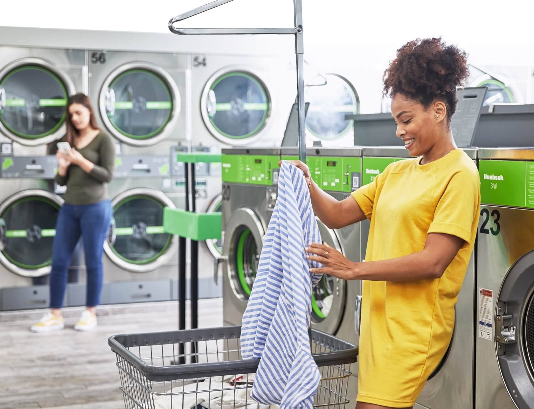 Women folding laundry at Huebsch laundromat