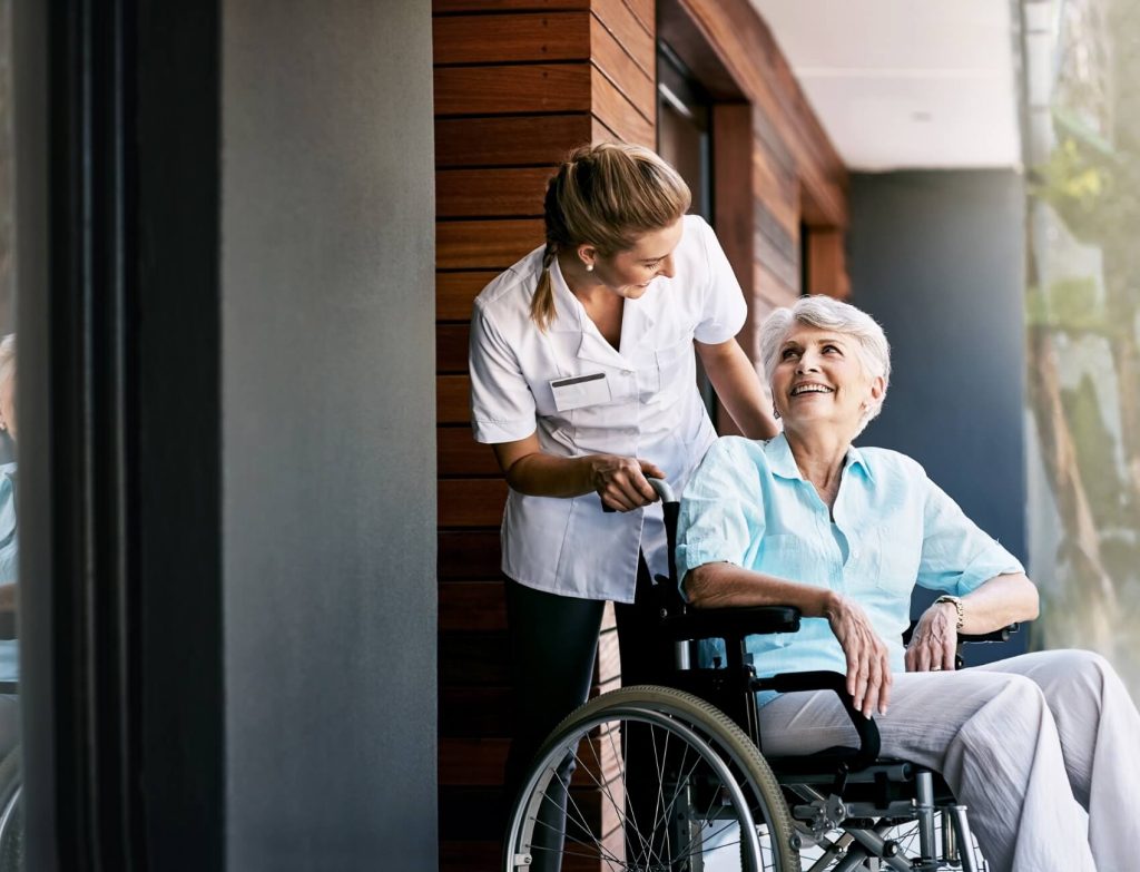 Woman in wheelchair being pushed by caregiver