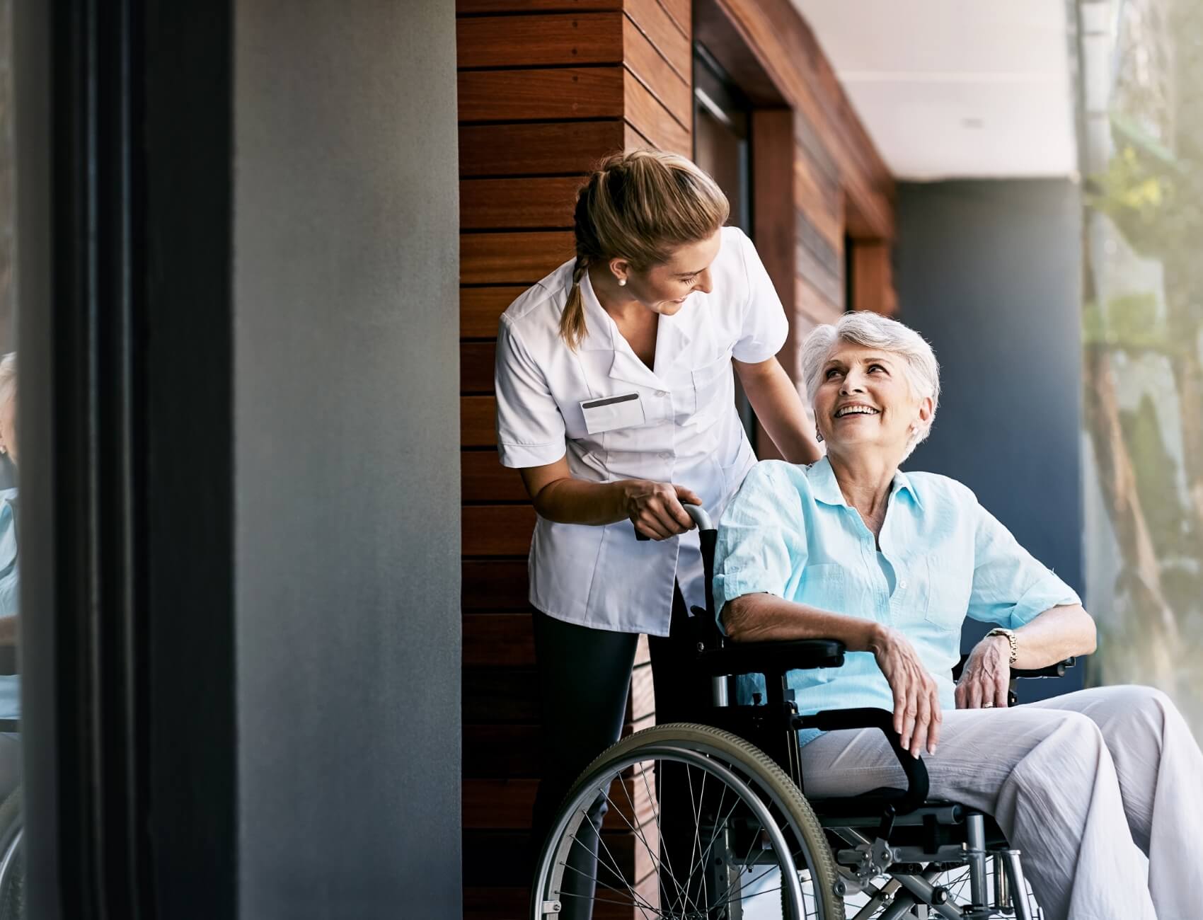 unimac-inline Woman in wheelchair being pushed by caregiver