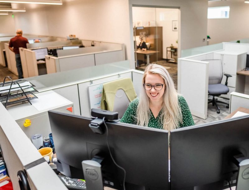 Female Alliance employee in office cubicle