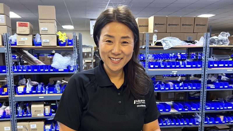 Alliance Laundry Systems employee smiling while parts stocking