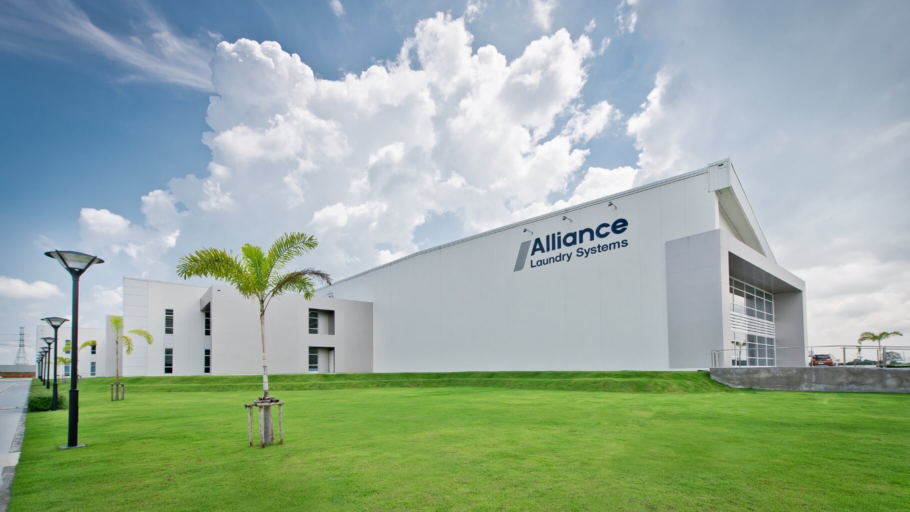 dramatic shot of Alliance building with walkway, lamp posts and palm trees