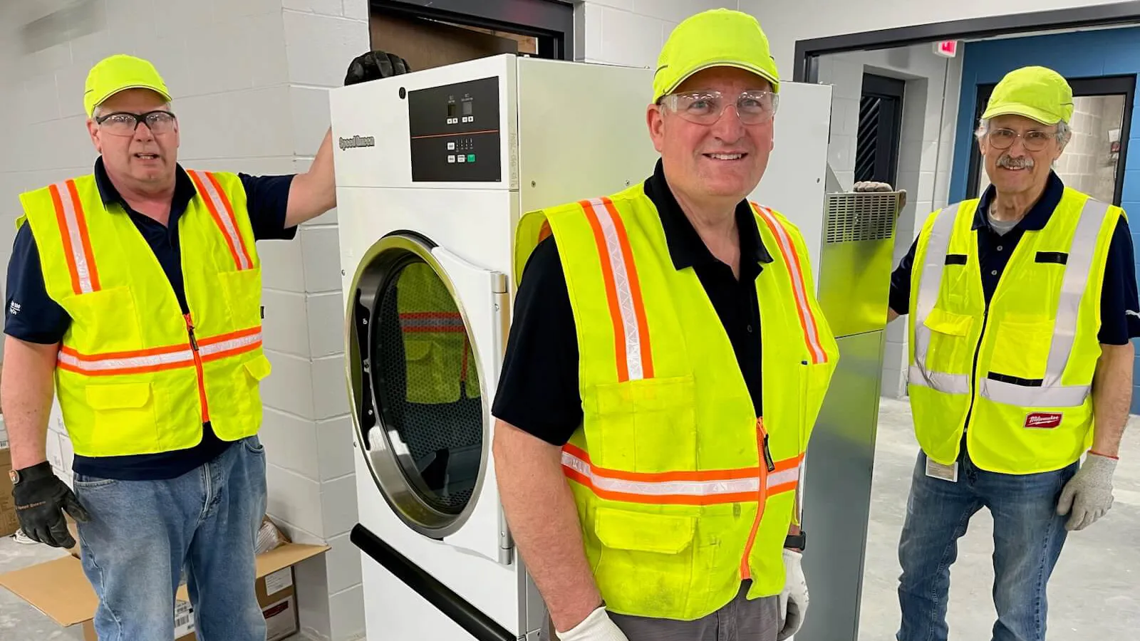 cares-hero Three Alliance employees during installation of gifted laundry equipment