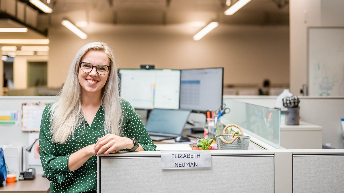 Alliance corporate employee posing in cubicle