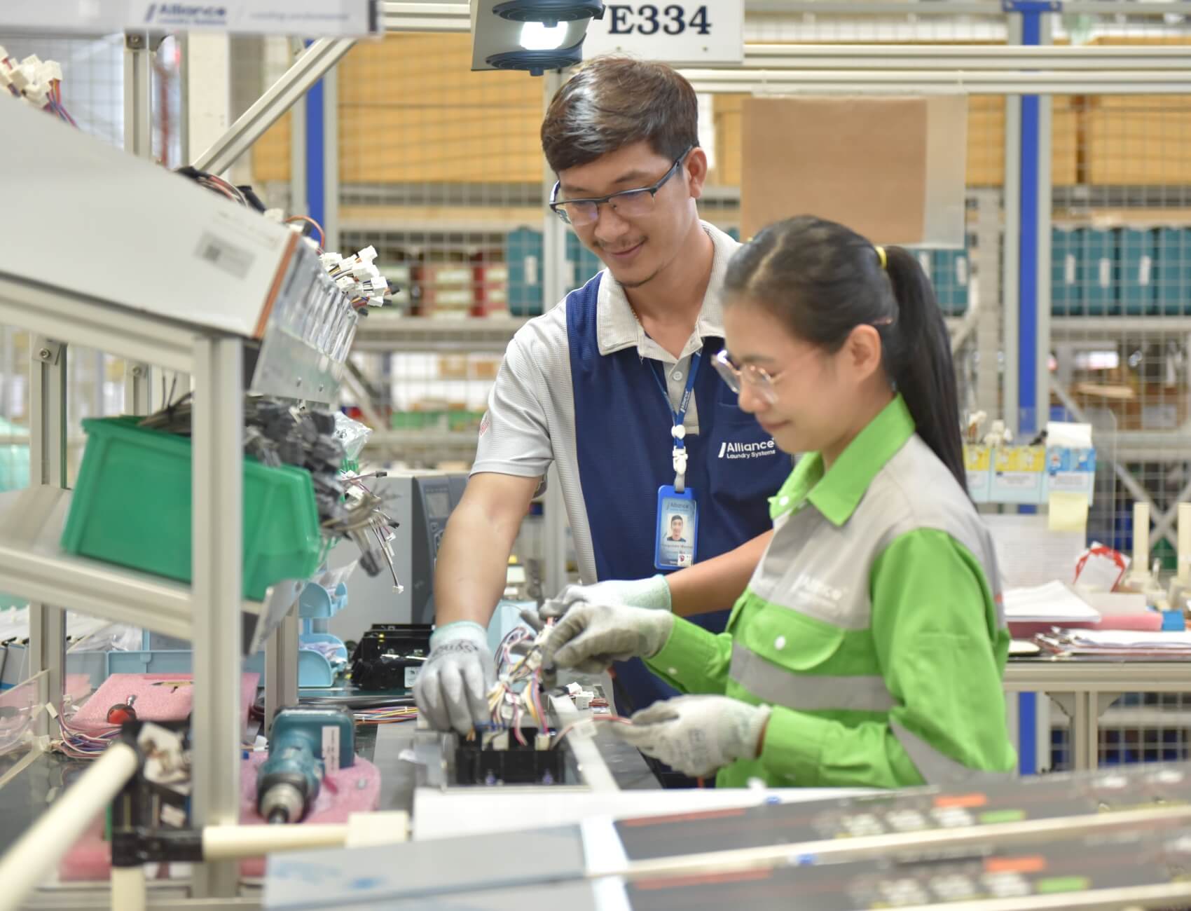 one-team two employees working together on machine part wiring