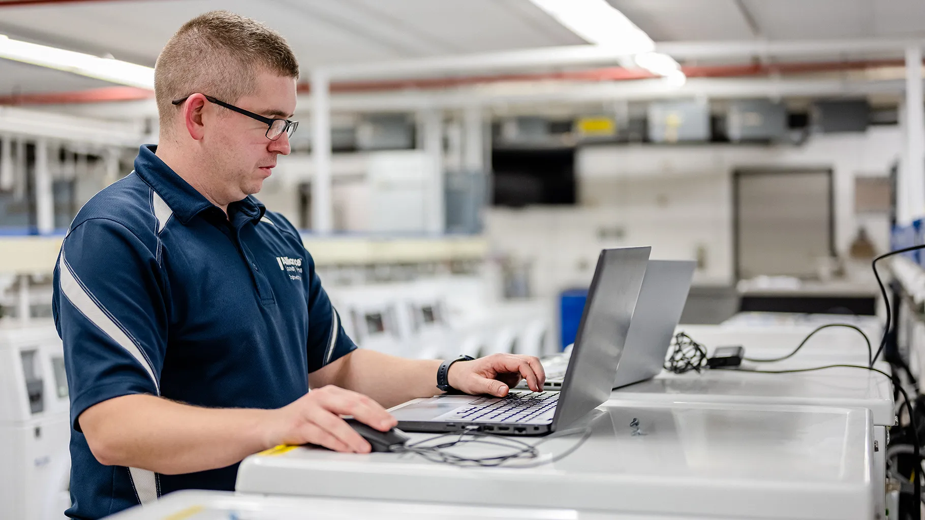 Alliance Laundry Systems employee working on laptop in laundry facility